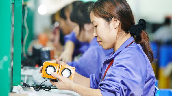 Asian women assembling electronic devices in a factory